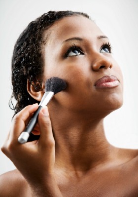 Beautiful-black-woman-applying-makeup-acne-free-skin